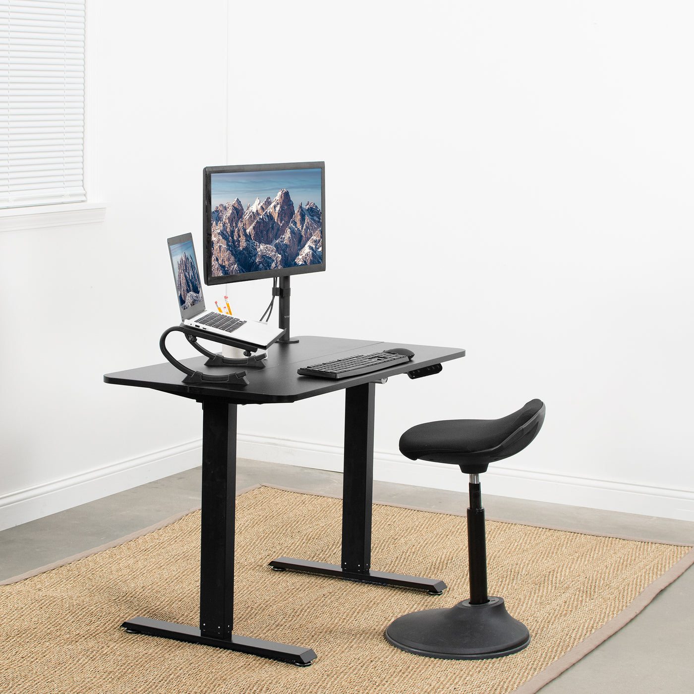 Small height adjustable desk in an office workspace.