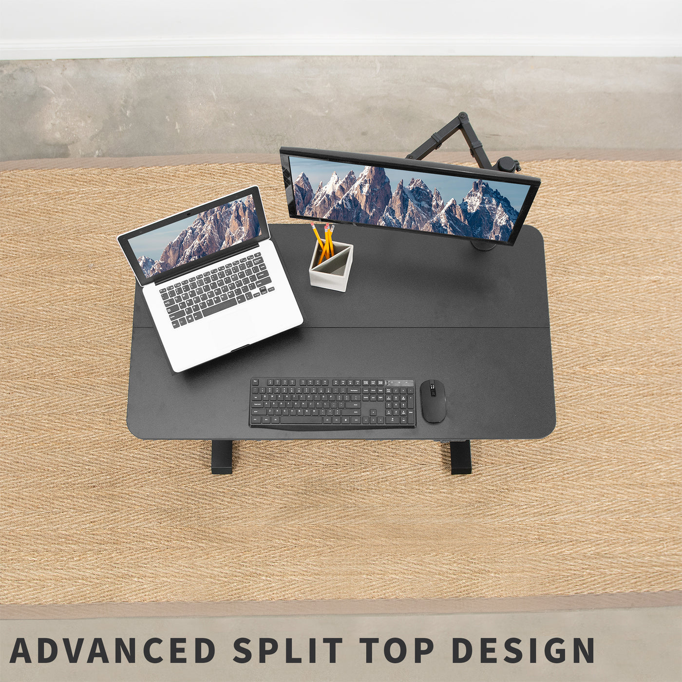 Black electric split top design desk supporting laptop, monitor, keyboard, mouse, and other office accessories.
