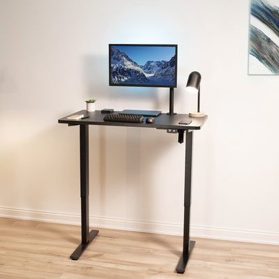 Sit to stand desk extended to standing level in an office space.
